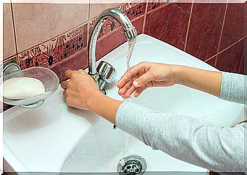 Girl washes right hand in the sink