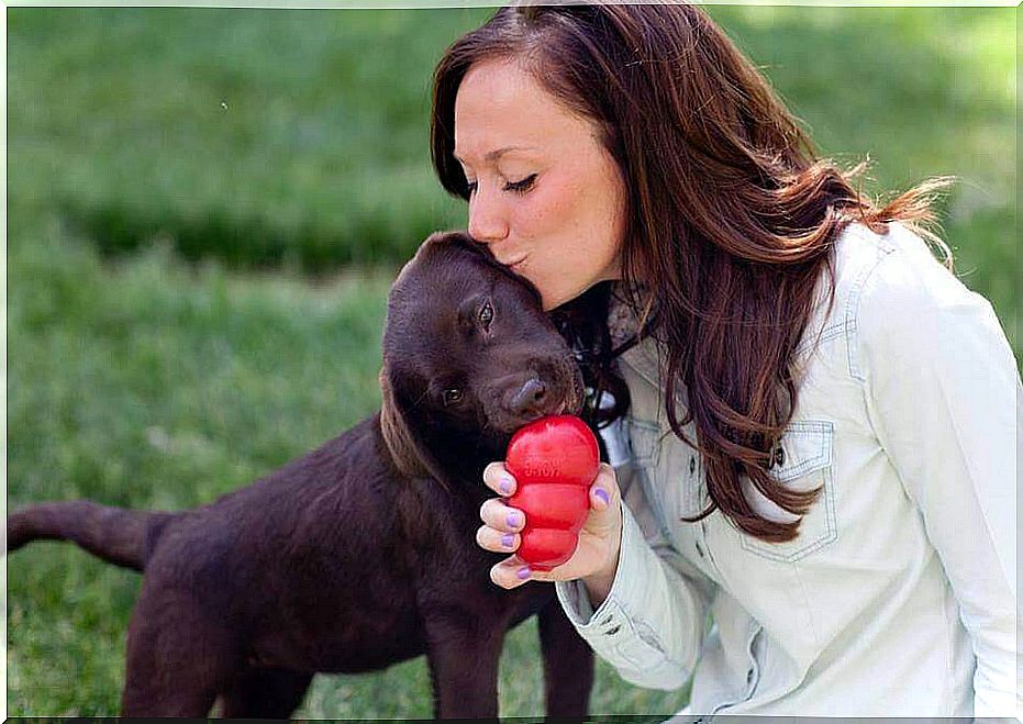 Mistress kisses her dog during a game